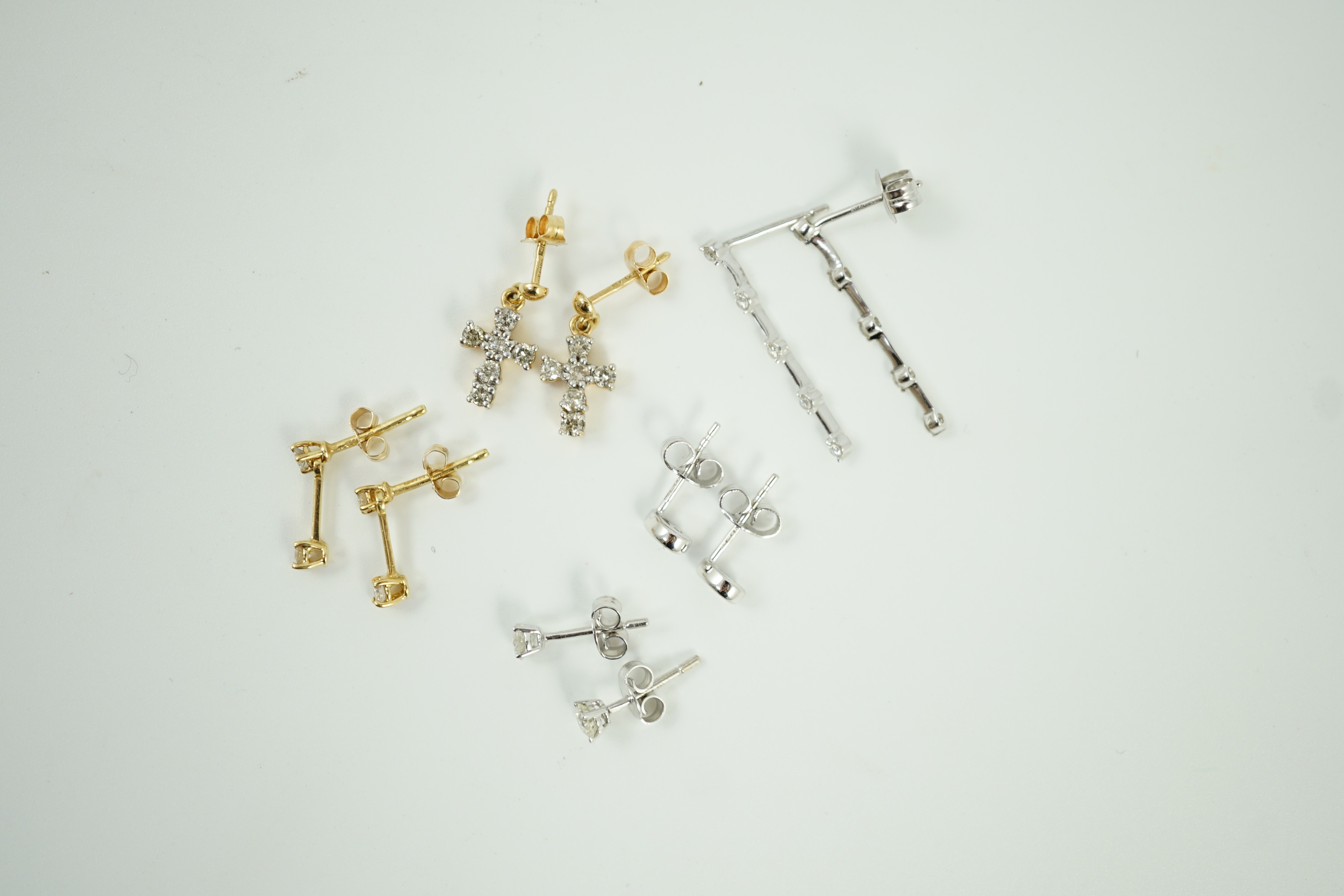 Three pairs of 18ct white gold and diamond set ear rings, including solitaire ear studs and two other pairs of 18ct gold and diamond set ear studs including cross, largest 24mm, gross weight 6.4 grams.